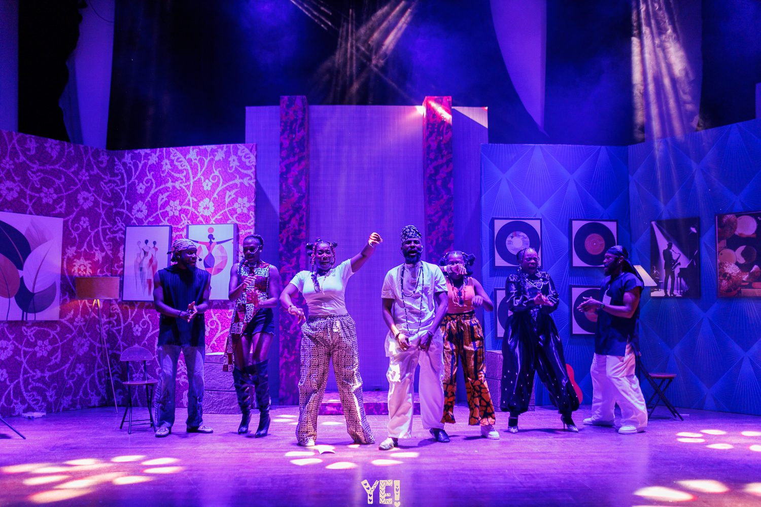 The YE! cast lined up across the stage in purple light