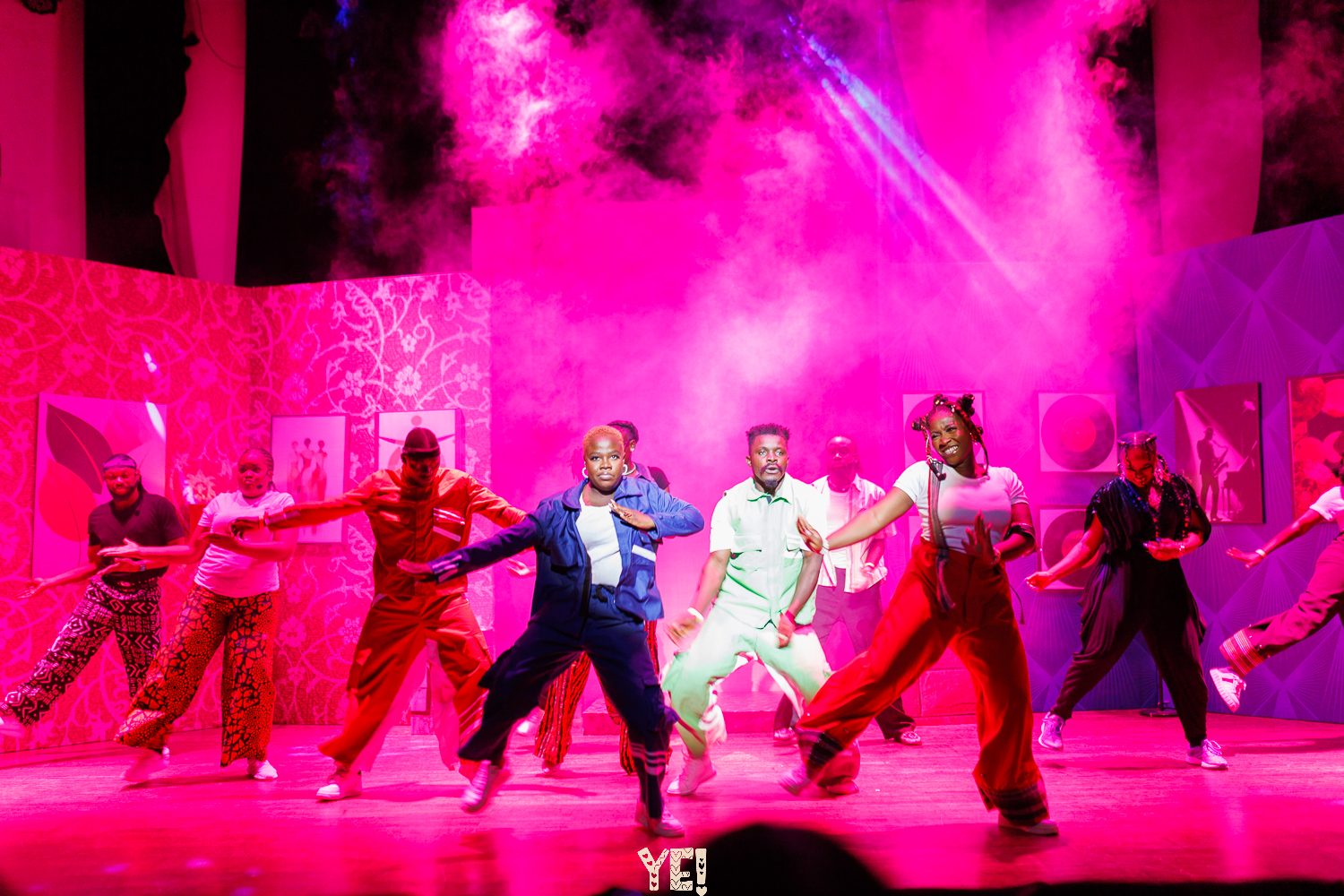 The YE! company dancing through pink haze